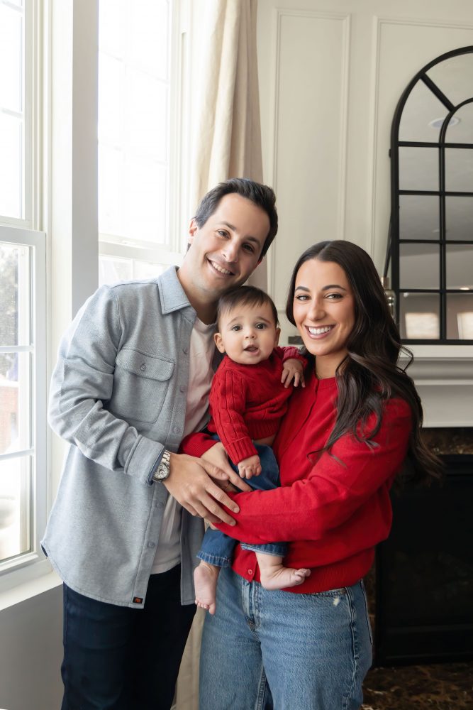 Cleveland in-home family photoshoot with mom, dad, and baby boy featuring natural light lifestyle photography, cozy candid moments, Valentine’s theme with red sweaters and chocolates, and their family dog