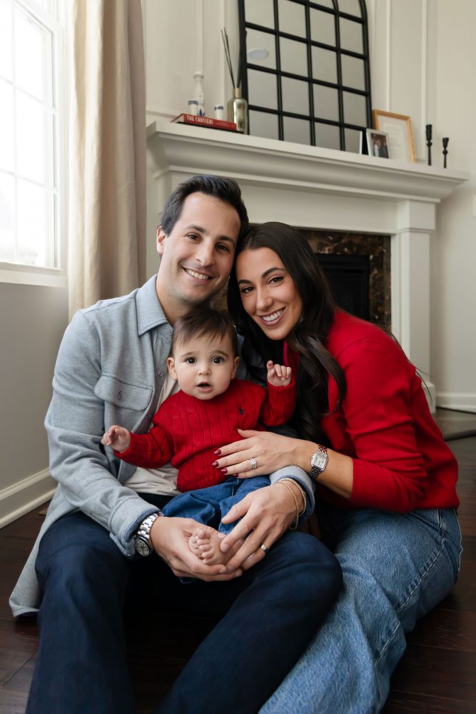 Cleveland in-home family photoshoot with mom, dad, and baby boy featuring natural light lifestyle photography, cozy candid moments, Valentine’s theme with red sweaters and chocolates, and their family dog