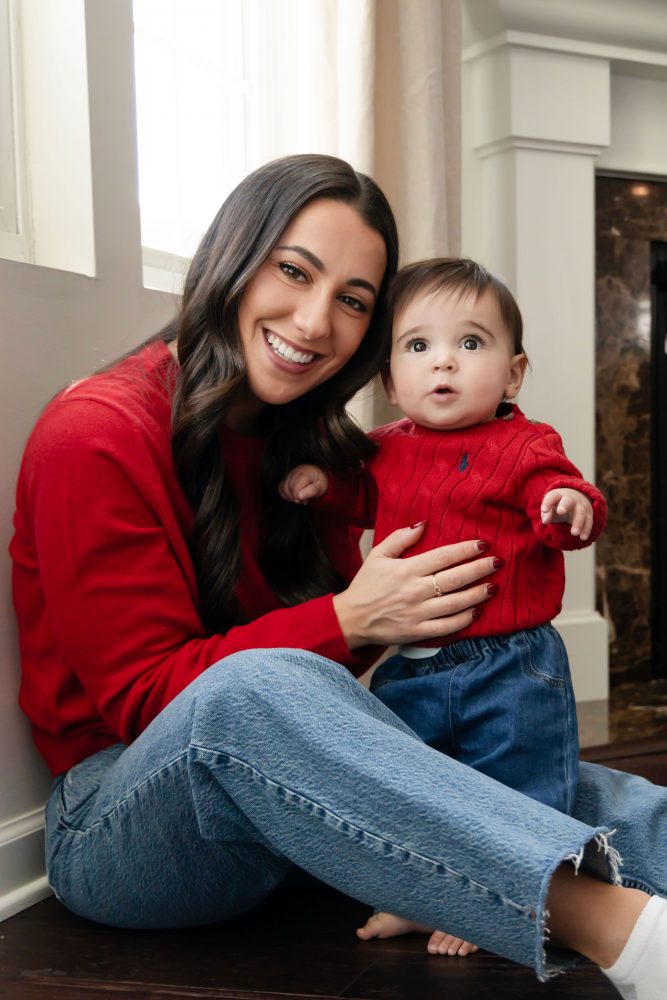 Cleveland in-home family photoshoot with mom, dad, and baby boy featuring natural light lifestyle photography, cozy candid moments, Valentine’s theme with red sweaters and chocolates, and their family dog