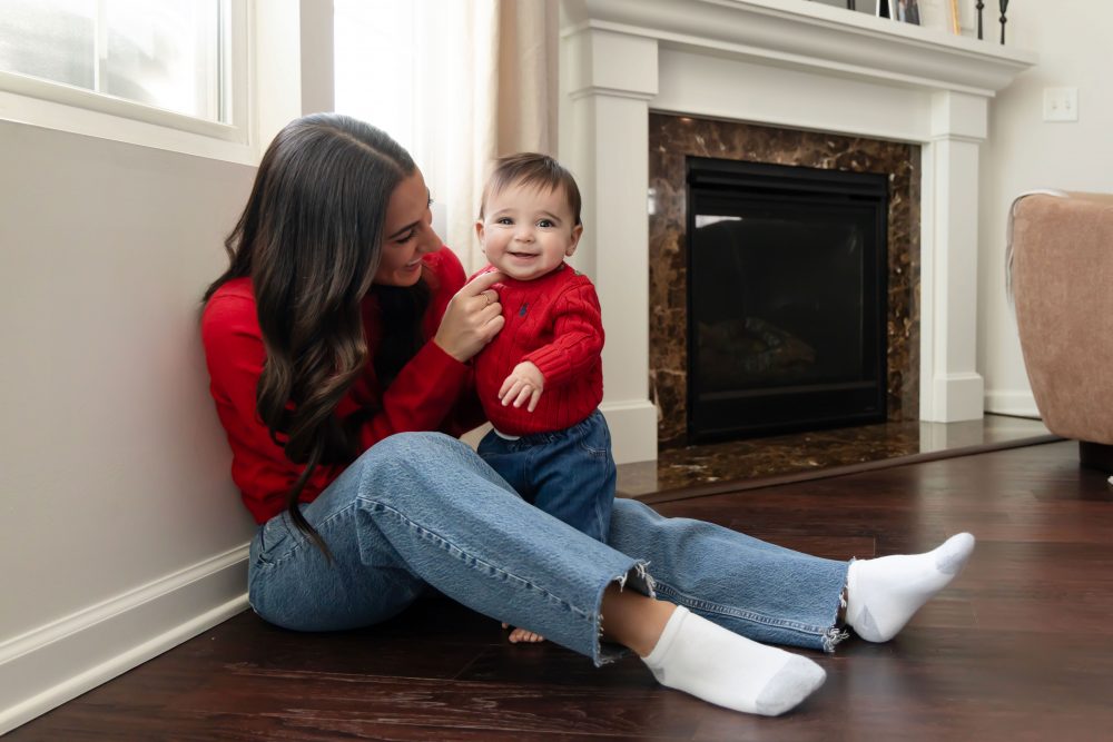 Cleveland in-home family photoshoot with mom, dad, and baby boy featuring natural light lifestyle photography, cozy candid moments, Valentine’s theme with red sweaters and chocolates, and their family dog