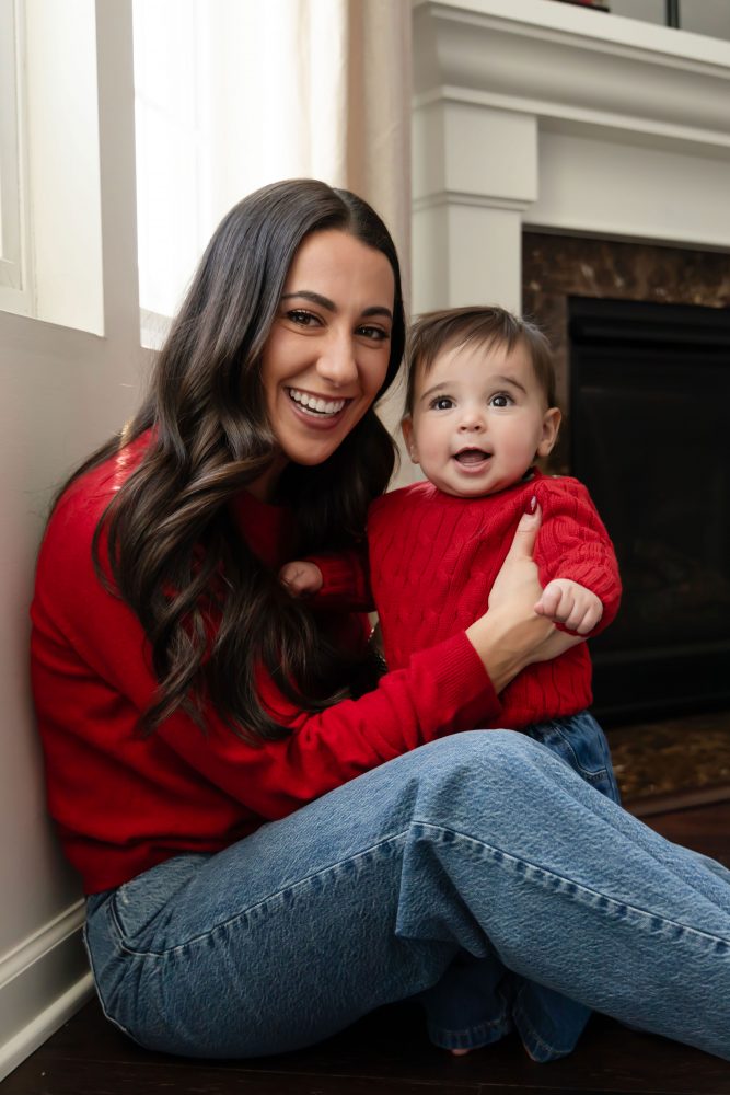 Cleveland in-home family photoshoot with mom, dad, and baby boy featuring natural light lifestyle photography, cozy candid moments, Valentine’s theme with red sweaters and chocolates, and their family dog