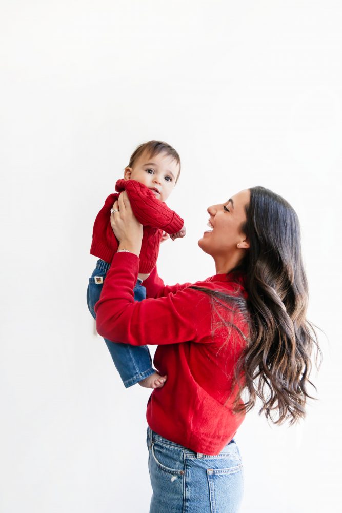 Cleveland in-home family photoshoot with mom, dad, and baby boy featuring natural light lifestyle photography, cozy candid moments, Valentine’s theme with red sweaters and chocolates, and their family dog