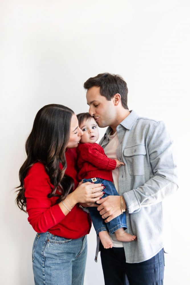 Cleveland in-home family photoshoot with mom, dad, and baby boy featuring natural light lifestyle photography, cozy candid moments, Valentine’s theme with red sweaters and chocolates, and their family dog
