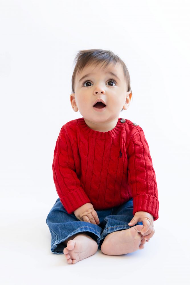 Cleveland in-home family photoshoot with mom, dad, and baby boy featuring natural light lifestyle photography, cozy candid moments, Valentine’s theme with red sweaters and chocolates, and their family dog