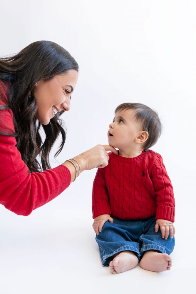 Cleveland in-home family photoshoot with mom, dad, and baby boy featuring natural light lifestyle photography, cozy candid moments, Valentine’s theme with red sweaters and chocolates, and their family dog