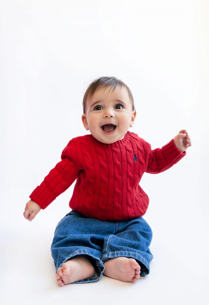 Cleveland in-home family photoshoot with mom, dad, and baby boy featuring natural light lifestyle photography, cozy candid moments, Valentine’s theme with red sweaters and chocolates, and their family dog