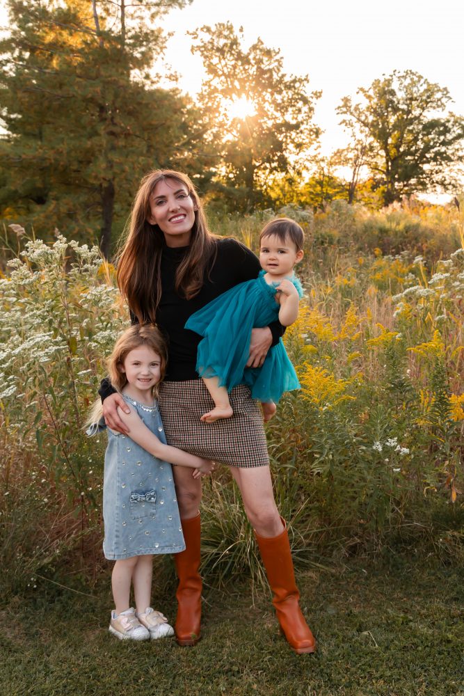 Mother with two young daughters hugging during outdoor sunset photography session in Cleveland Ohio