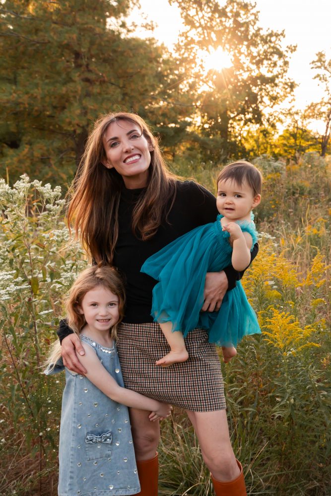 Mother with two young daughters hugging during outdoor sunset photography session in Cleveland Ohio