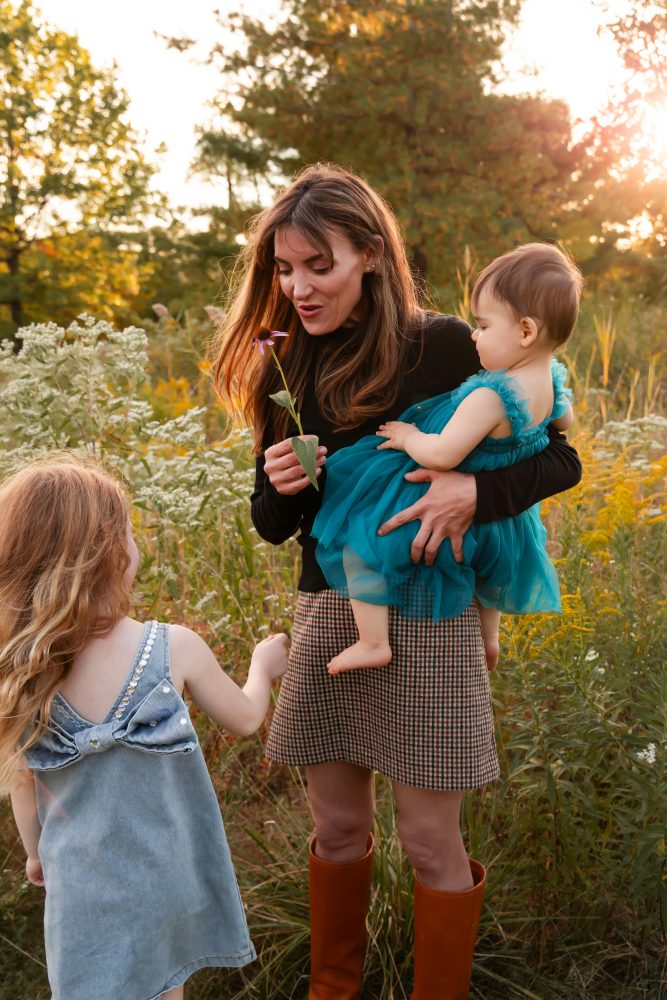 Mother with two young daughters hugging during outdoor sunset photography session in Cleveland Ohio