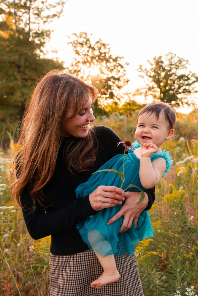 Mother with two young daughters hugging during outdoor sunset photography session in Cleveland Ohio
