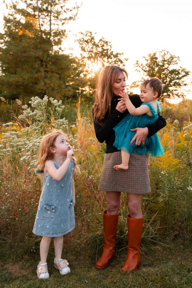 Mother with two young daughters hugging during outdoor sunset photography session in Cleveland Ohio
