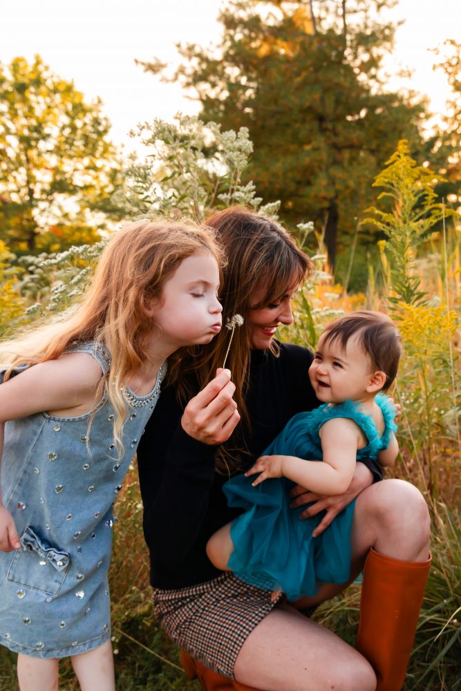 Mother with two young daughters hugging during outdoor sunset photography session in Cleveland Ohio