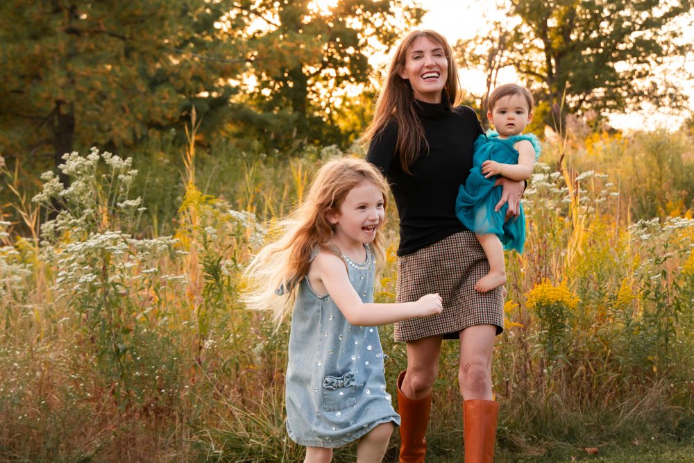 Sisters laughing with their mom in warm sunset light Cleveland Ohio family photography