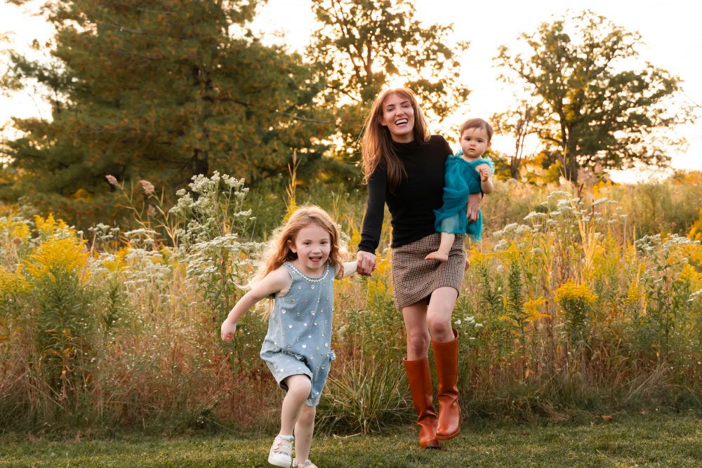 Sisters laughing with their mom in warm sunset light Cleveland Ohio family photography
