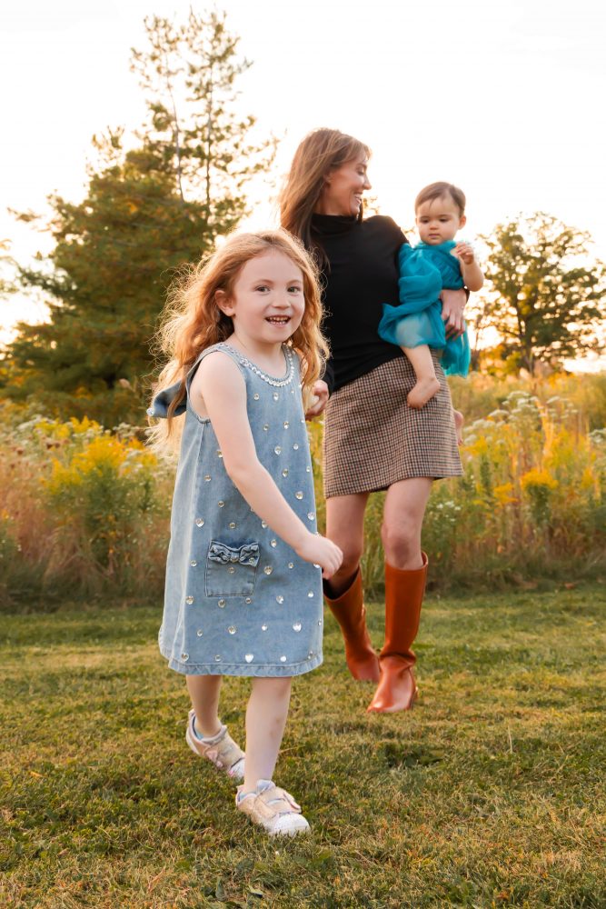 Sisters laughing with their mom in warm sunset light Cleveland Ohio family photography