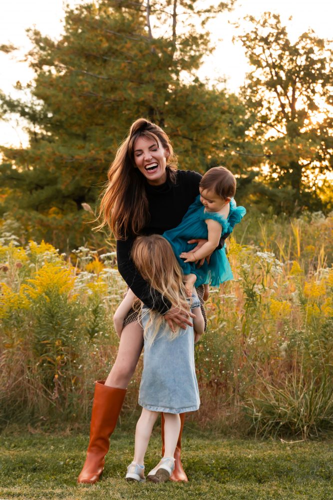 Sisters laughing with their mom in warm sunset light Cleveland Ohio family photography