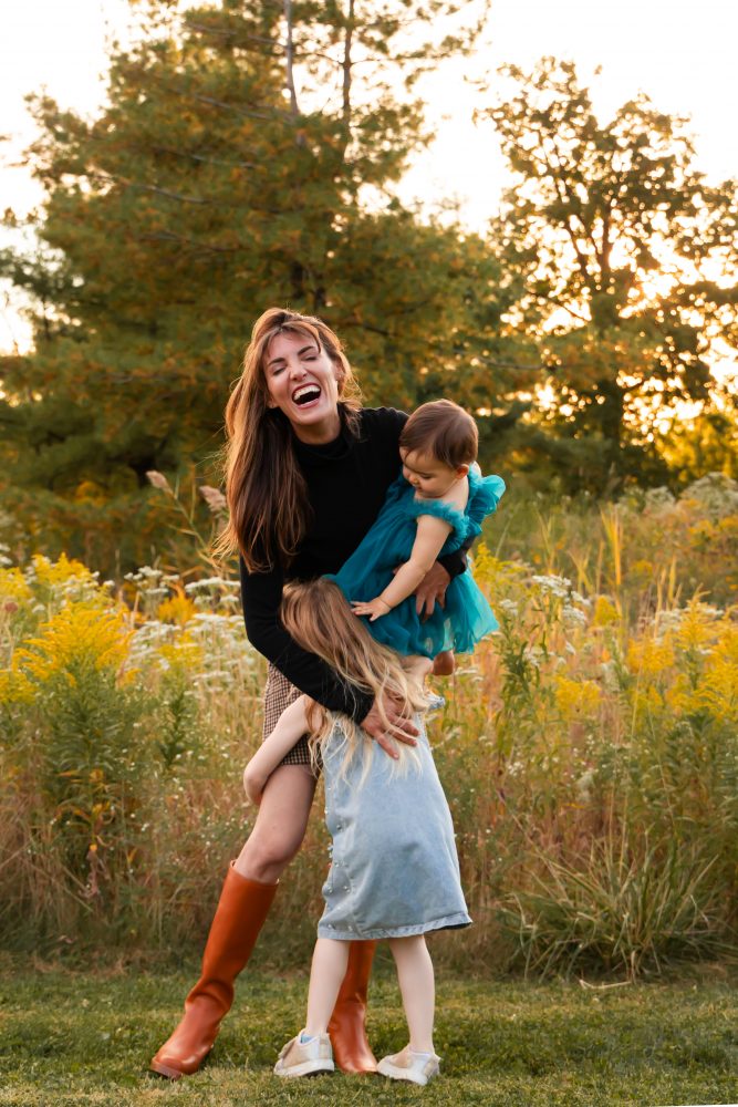 Sisters laughing with their mom in warm sunset light Cleveland Ohio family photography