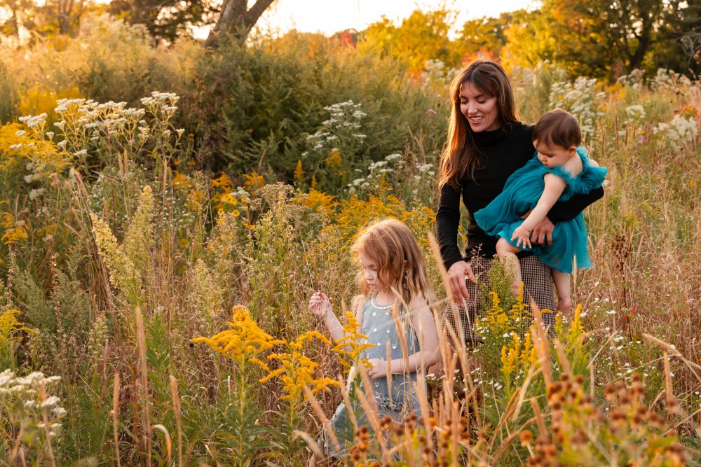 Sisters laughing with their mom in warm sunset light Cleveland Ohio family photography