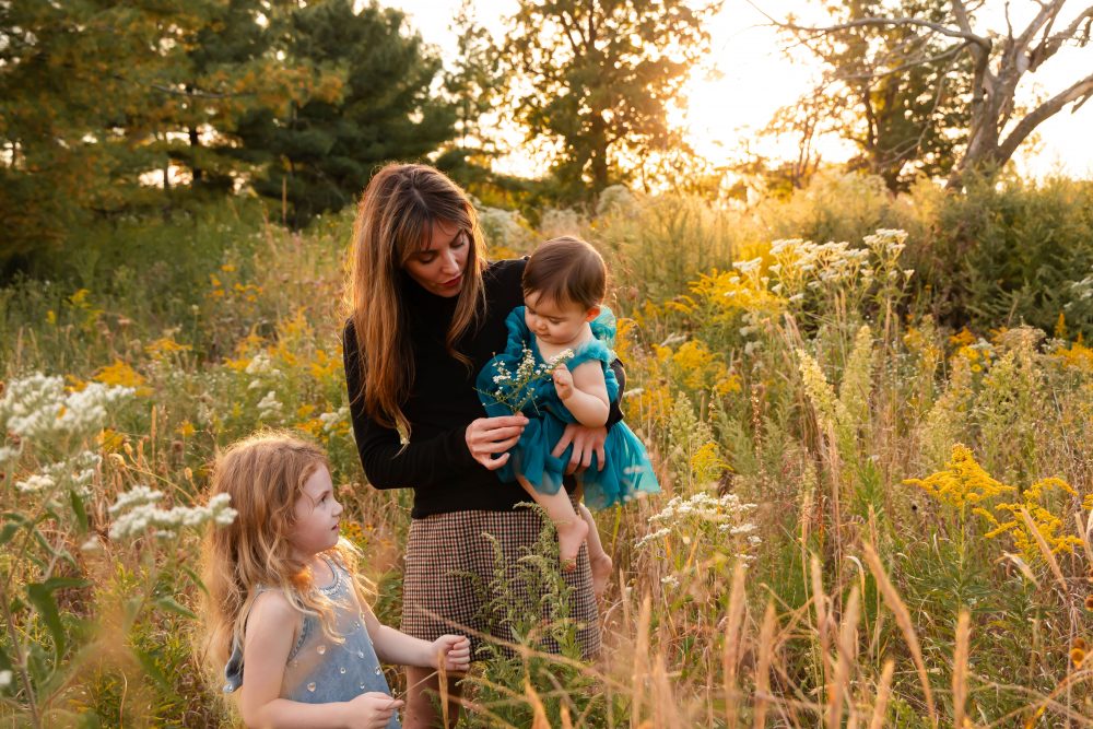 Sisters laughing with their mom in warm sunset light Cleveland Ohio family photography