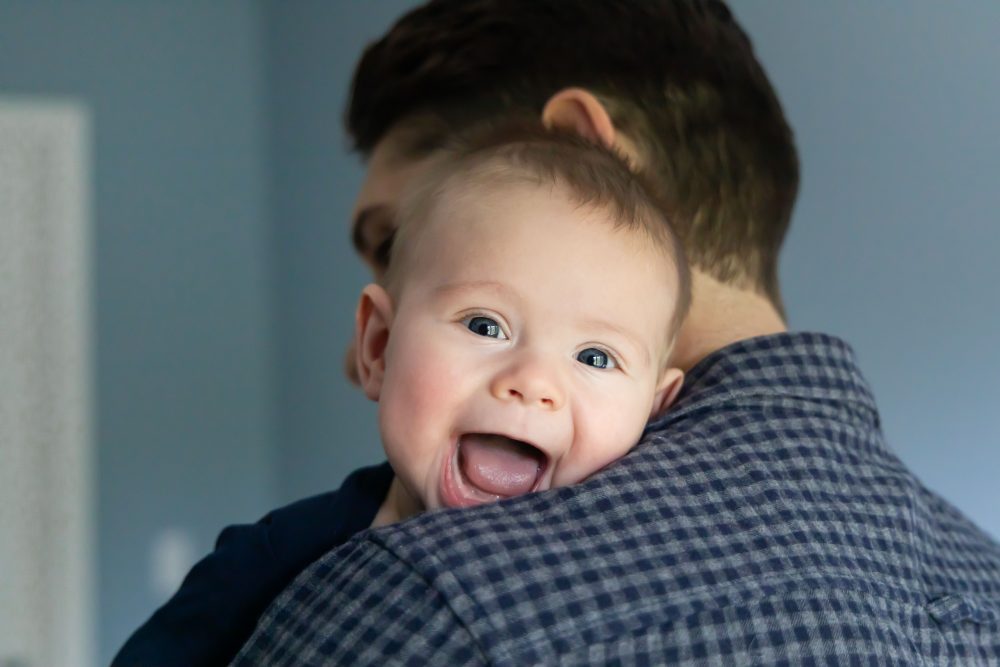 Lifestyle family portrait of parents with their newborn baby boy during in-home session in Cleveland Ohio.