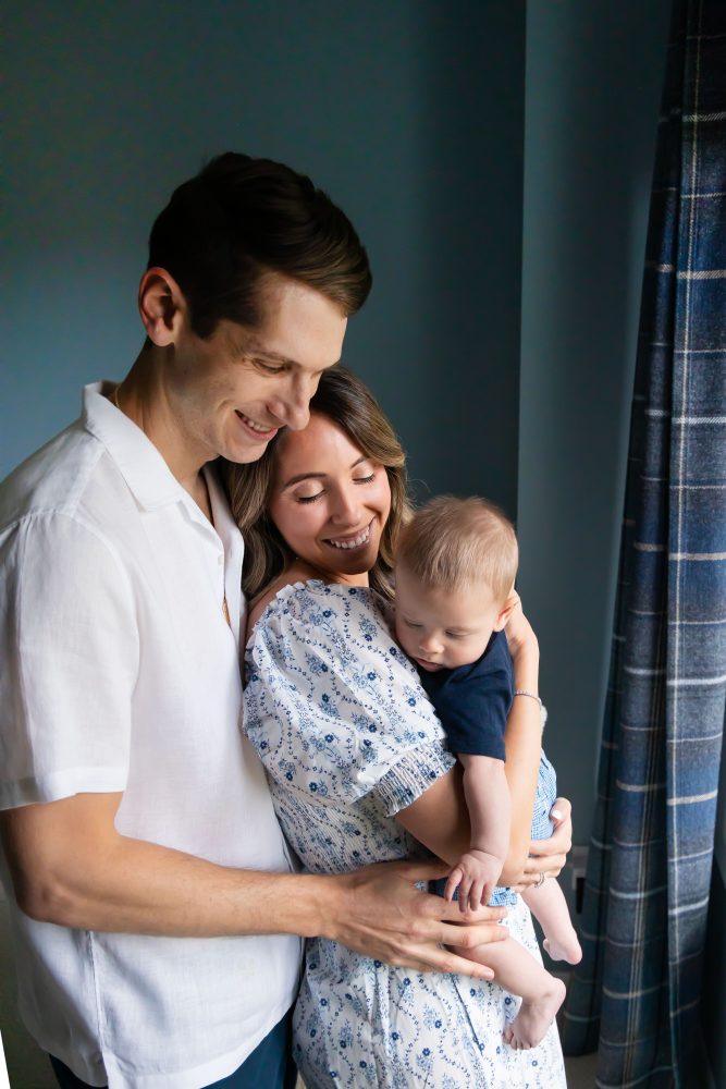 Lifestyle family portrait of parents with their newborn baby boy during in-home session in Cleveland Ohio.