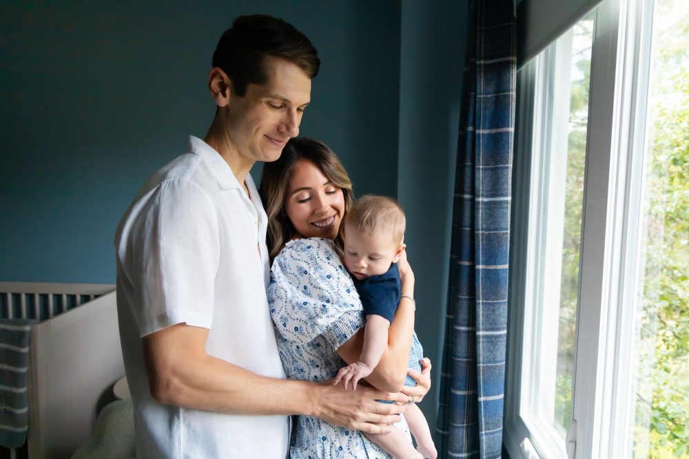 Lifestyle family portrait of parents with their newborn baby boy during in-home session in Cleveland Ohio.