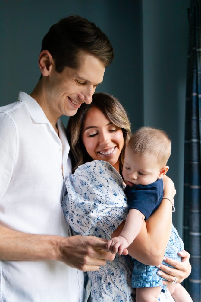 Lifestyle family portrait of parents with their newborn baby boy during in-home session in Cleveland Ohio.