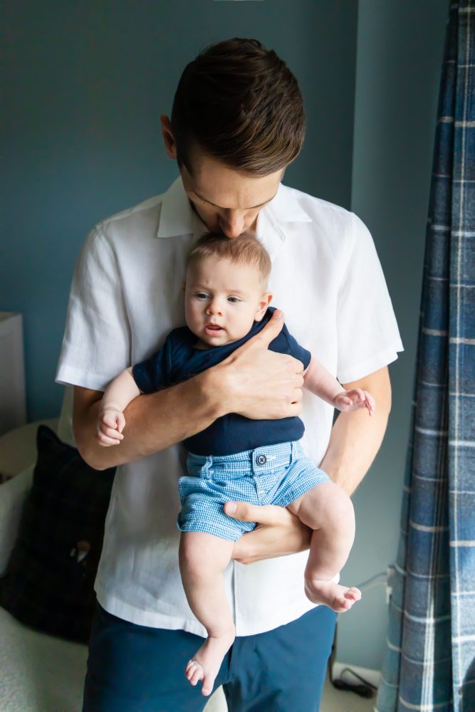 Lifestyle family portrait of parents with their newborn baby boy during in-home session in Cleveland Ohio.
