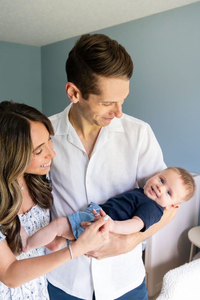 Lifestyle family portrait of parents with their newborn baby boy during in-home session in Cleveland Ohio.