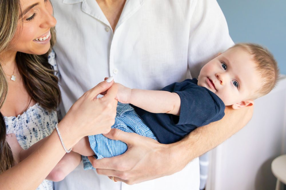Lifestyle family portrait of parents with their newborn baby boy during in-home session in Cleveland Ohio.