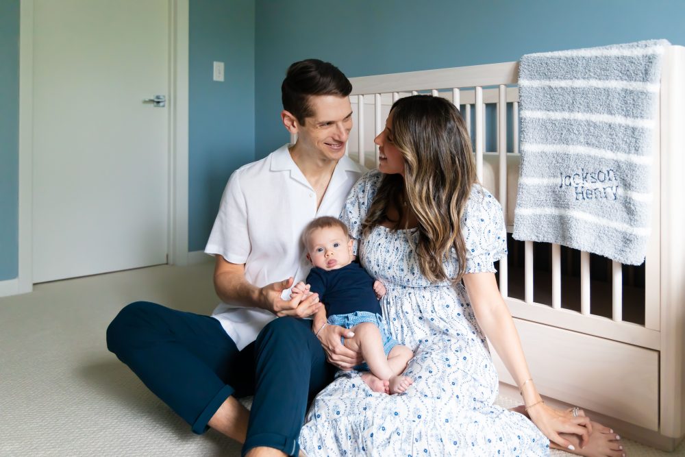 Lifestyle family portrait of parents with their newborn baby boy during in-home session in Cleveland Ohio.