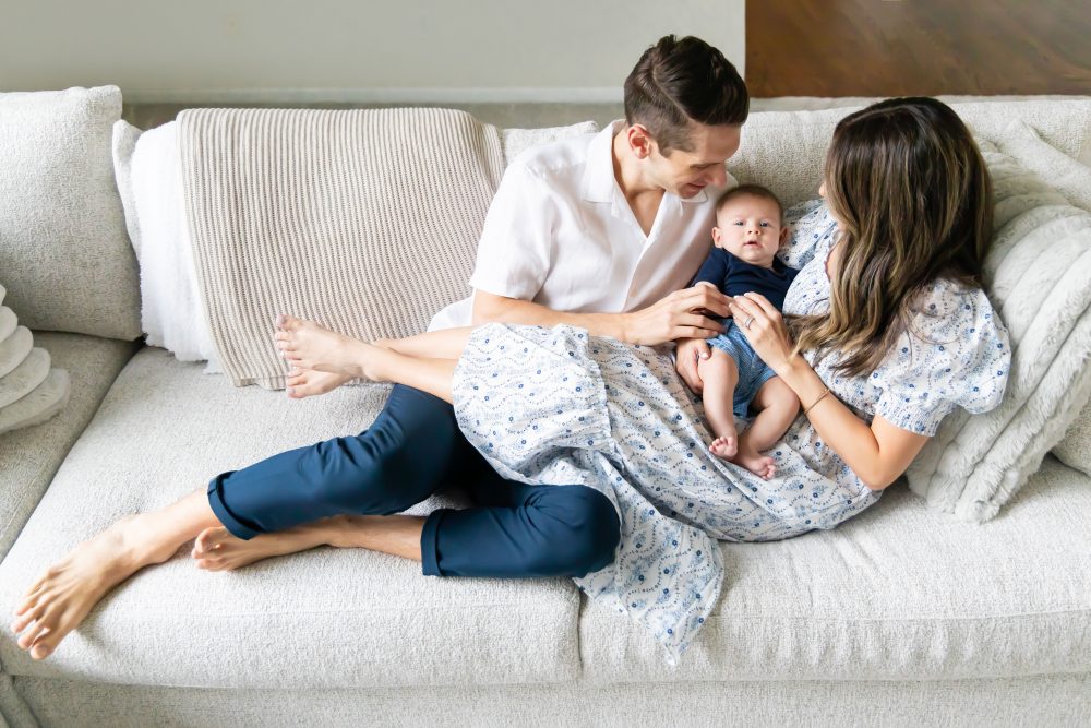 Lifestyle family portrait of parents with their newborn baby boy during in-home session in Cleveland Ohio.