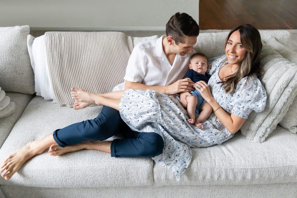 Lifestyle family portrait of parents with their newborn baby boy during in-home session in Cleveland Ohio.