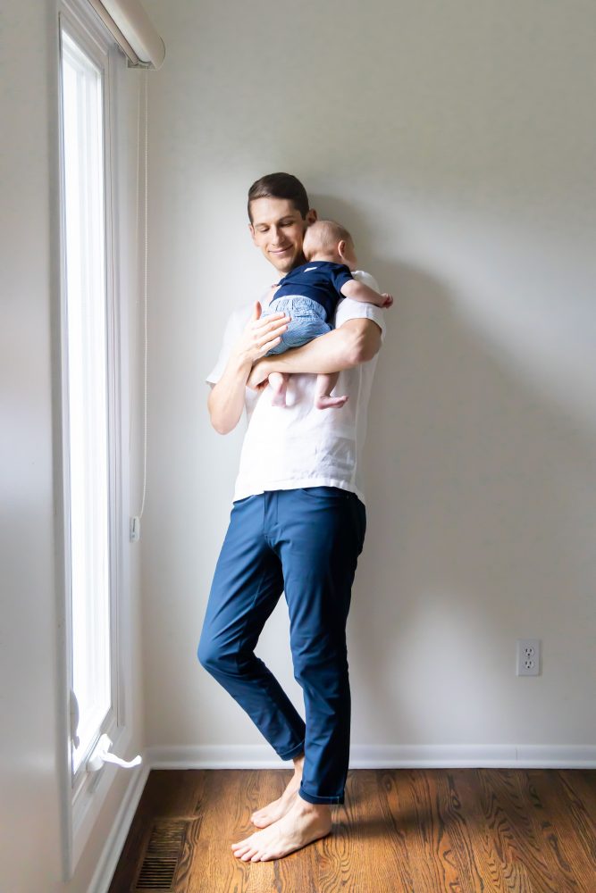 Lifestyle family portrait of parents with their newborn baby boy during in-home session in Cleveland Ohio.