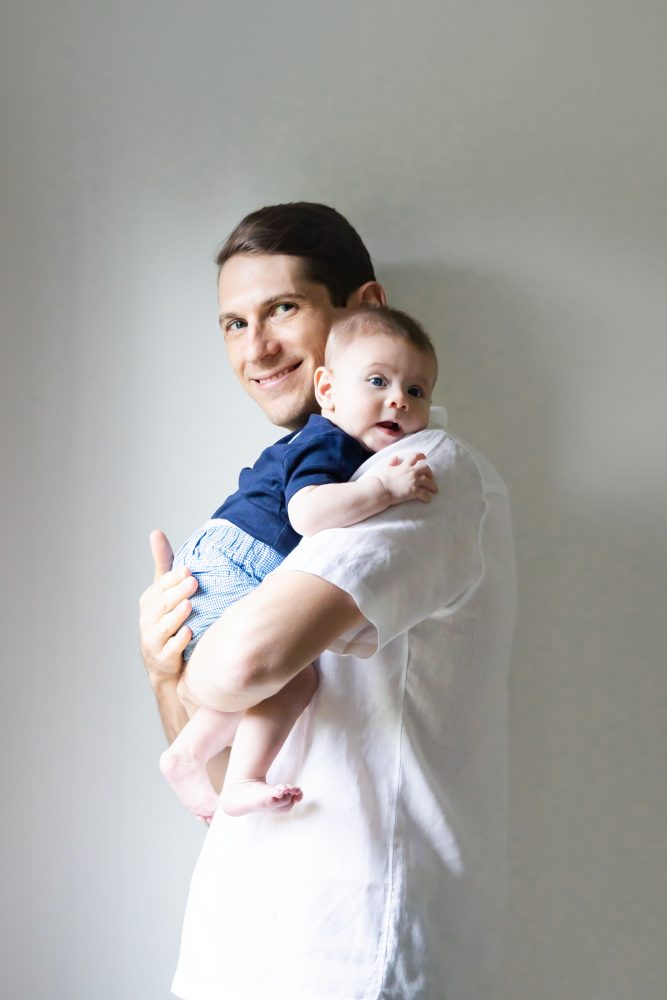 Lifestyle family portrait of parents with their newborn baby boy during in-home session in Cleveland Ohio.