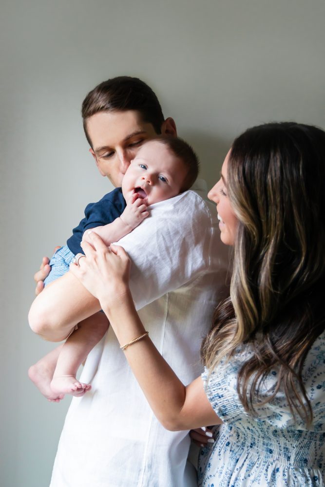 Lifestyle family portrait of parents with their newborn baby boy during in-home session in Cleveland Ohio.