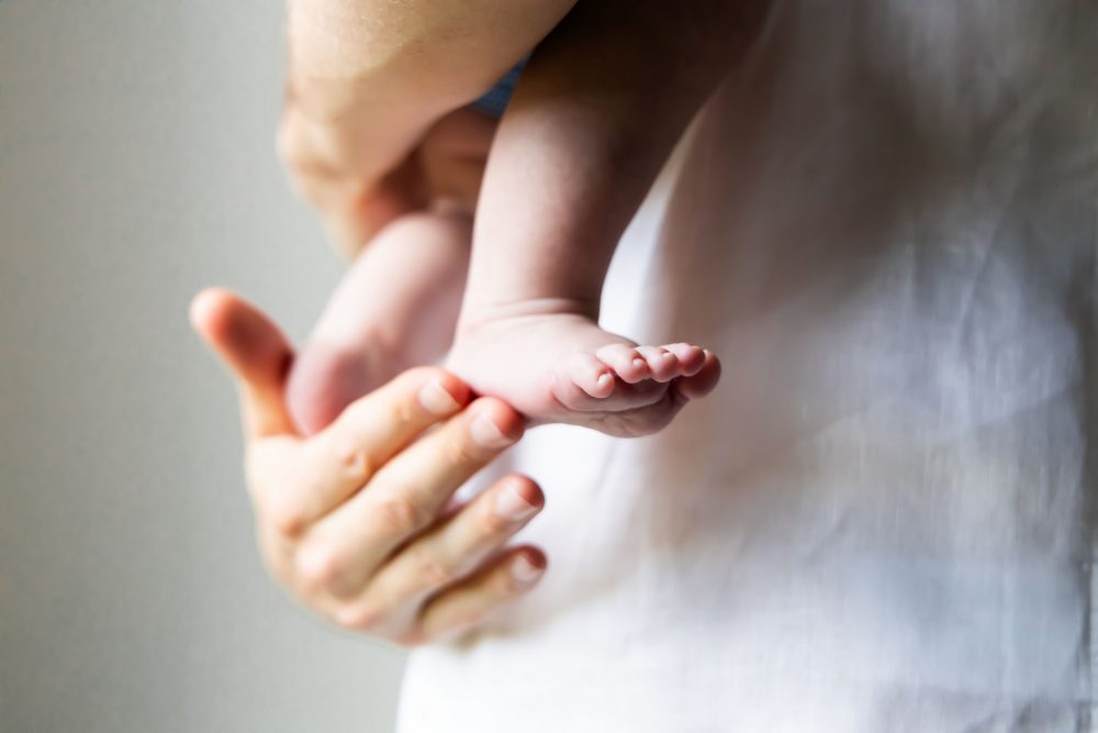 Lifestyle family portrait of parents with their newborn baby boy during in-home session in Cleveland Ohio.