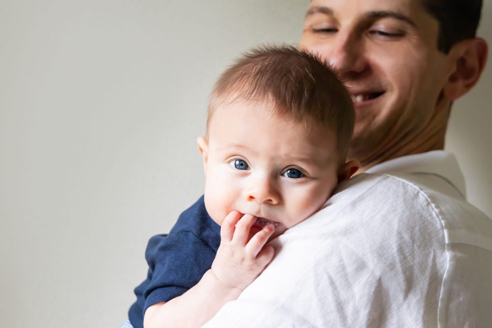 Lifestyle family portrait of parents with their newborn baby boy during in-home session in Cleveland Ohio.