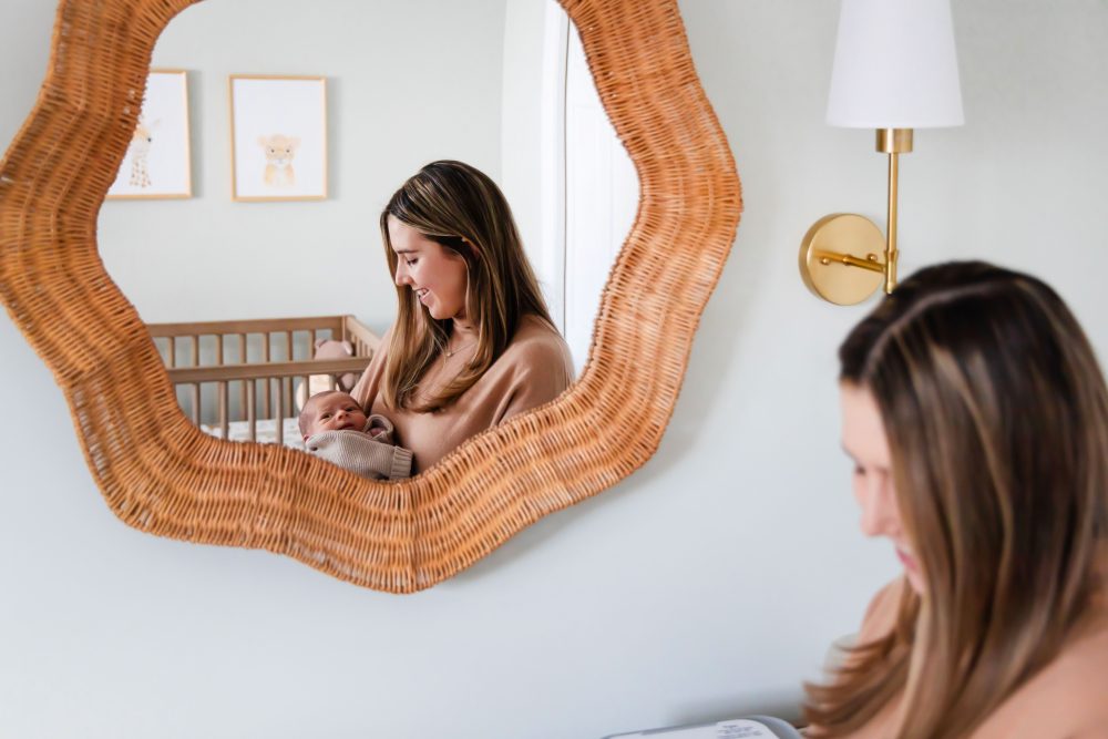 Cleveland newborn and family photographer captures a couple with their newborn baby in a cozy, softly lit nursery, featuring natural light and lifestyle moments in a Cleveland, Ohio home.