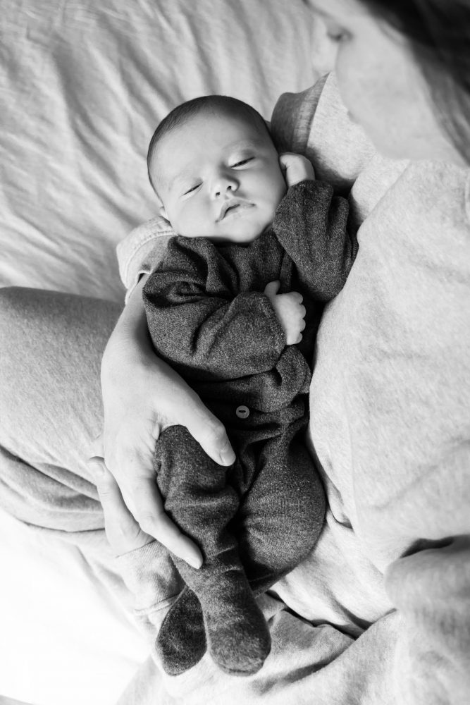 Lifestyle newborn photos of baby resting and stretching, minimal and natural Cleveland photographer
