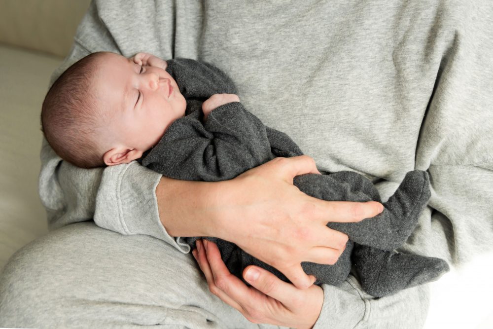 Lifestyle newborn photos of baby resting and stretching, minimal and natural Cleveland photographer