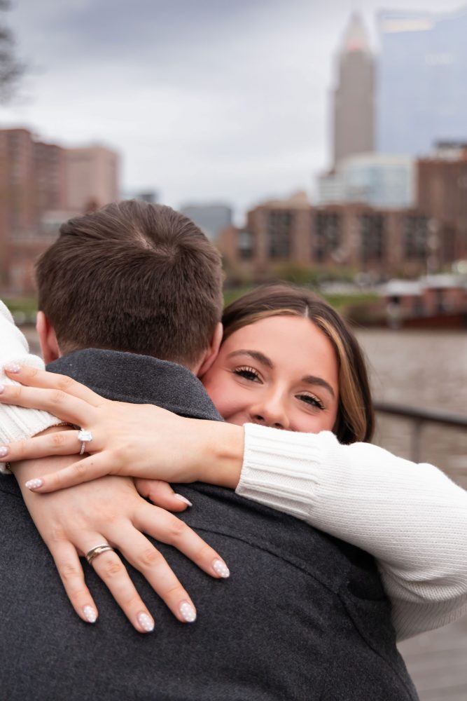 Newly engaged couple showing off engagement ring after surprise proposal in downtown Cleveland