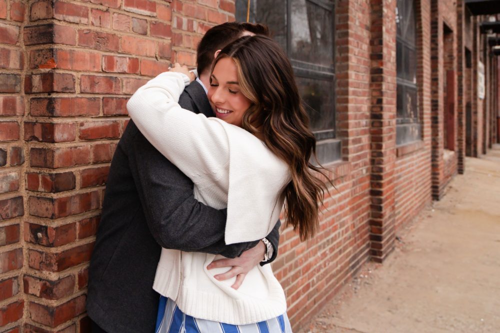 Newly engaged couple embracing after romantic proposal in downtown Cleveland, Ohio