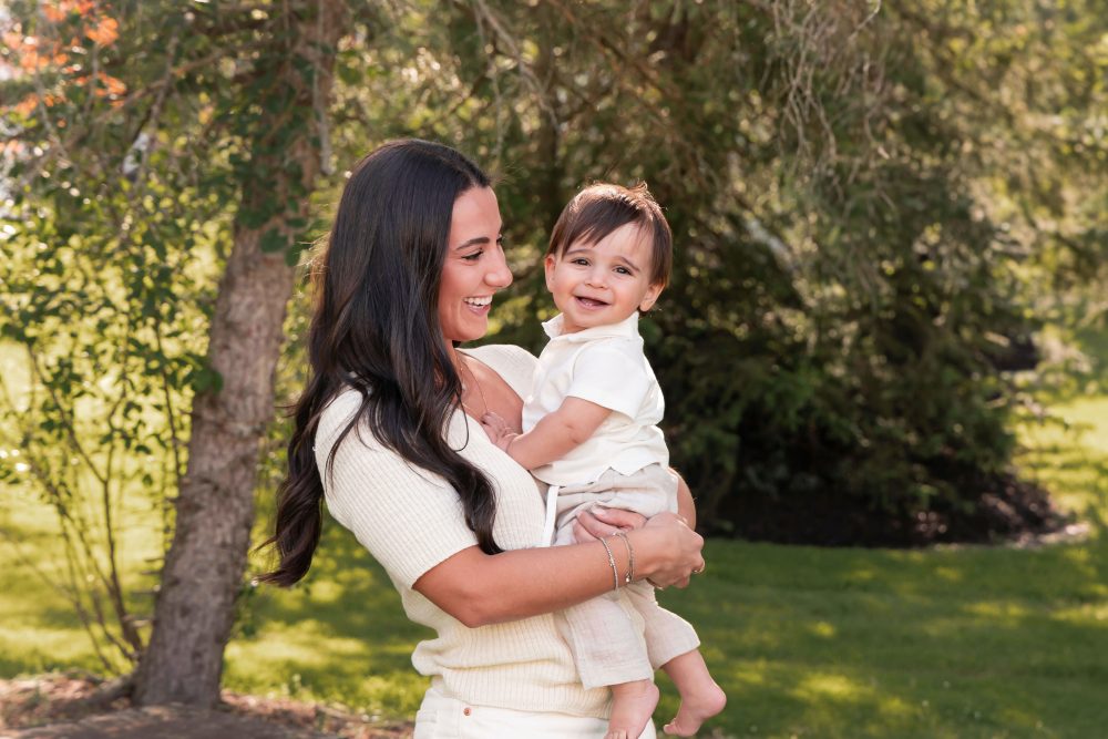 Happy family with their one-year-old baby boy enjoying an outdoor portrait session by Cleveland family photographer Allison Liffman Photography.