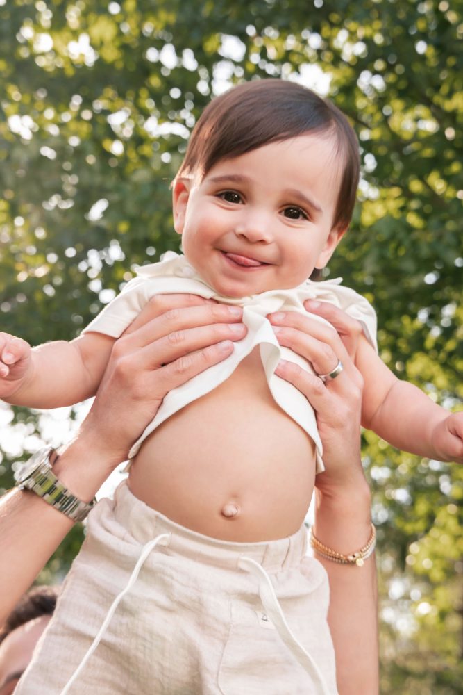 Natural outdoor family photos celebrating a baby's first birthday with parents in Cleveland, Ohio.