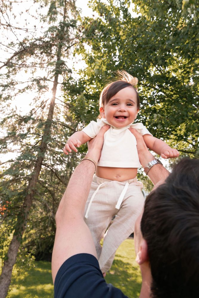 Natural outdoor family photos celebrating a baby's first birthday with parents in Cleveland, Ohio.