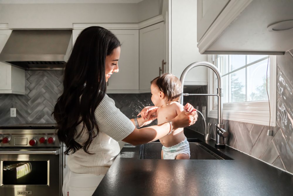 One year old taking a sink bath after a milestone cake smash photography session in Cleveland, Ohio by Allison Liffman Photography.