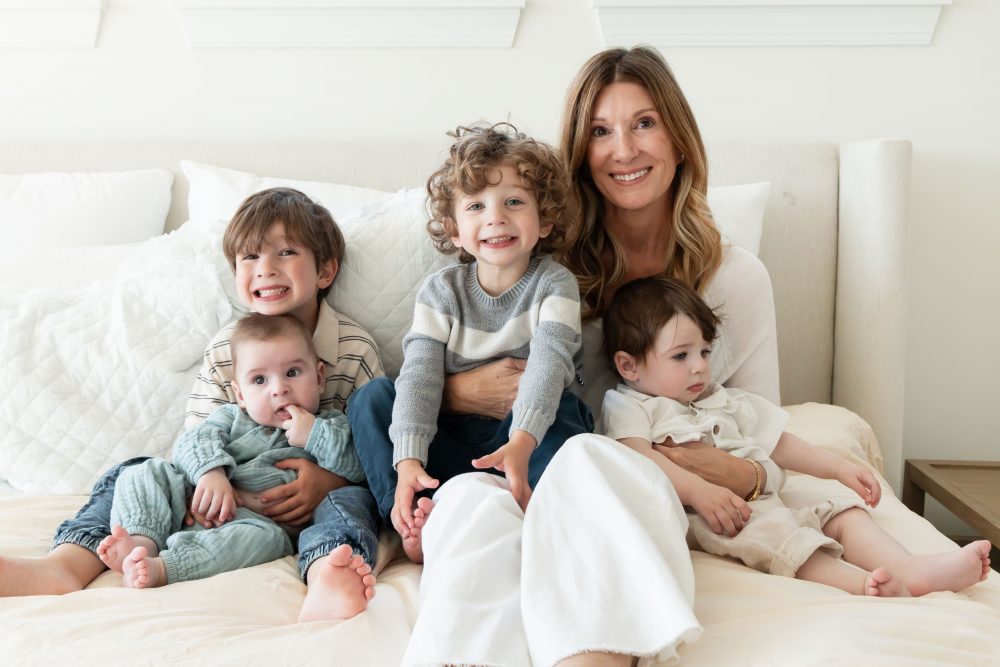 Mother laughing with her two young sons during an in-home lifestyle family photography session by a Cleveland family photographer.