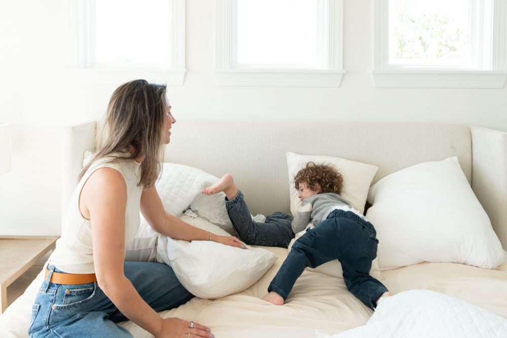 Mother laughing with her two young sons during an in-home lifestyle family photography session by a Cleveland family photographer.