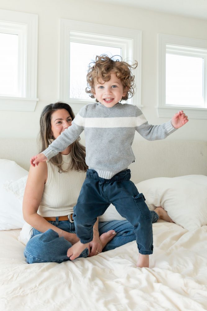 Mother laughing with her two young sons during an in-home lifestyle family photography session by a Cleveland family photographer.